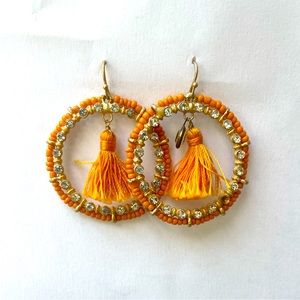 Orange beaded hoop earrings with fringe detail